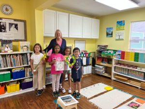 children with teacher holding their toys