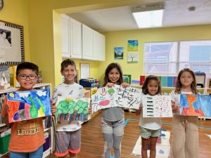 students showing their drawings