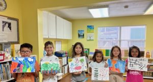 students showing their drawings